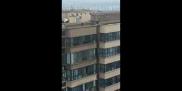 Un niño salta temerariamente de cornisa en cornisa entre dos edificios