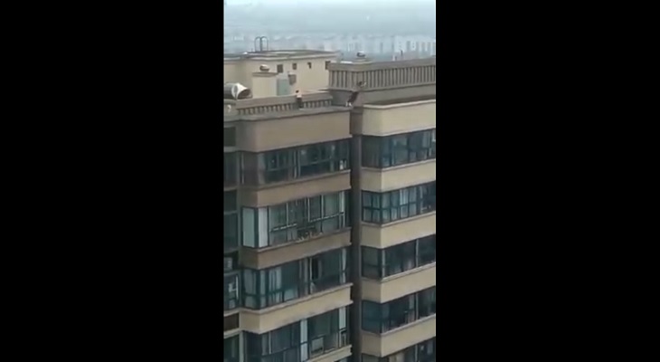 Un niño salta temerariamente de cornisa en cornisa entre dos edificios