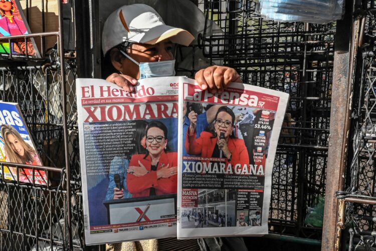A vendor shows the covers of newspapers depicting left-wing opposition candidate Xiomara Castro, in Tegucigalpa on November 29, 2021, a day after general elections in Honduras. - Left-wing opposition candidate Xiomara Castro took a commanding lead over the ruling party's Nasry Asfura, preliminary results showed. With just over half of votes counted, former first lady Castro had taken more than 53.5 percent with Asfura a distant second out of 13 candidates with 34 percent, according to a National Electoral Council (CNE) live count. (Photo by Orlando SIERRA / AFP)