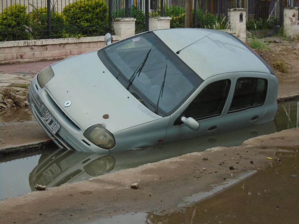 Por las intensas lluvias, un auto quedó atascado en una obra cloacal