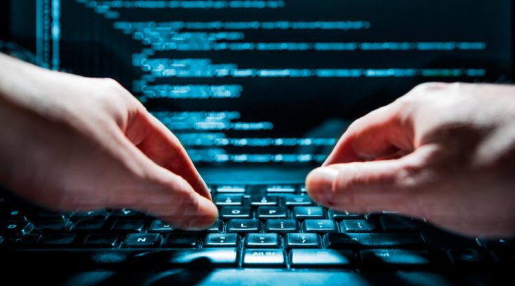 Hacker using laptop. Lots of digits on the computer screen.