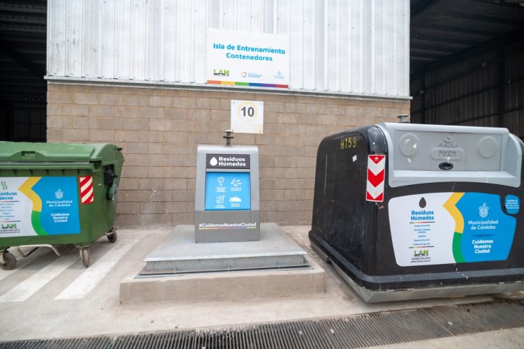 Al medio de la foto, se observa el nuevo contenedor que tendrá sobre la superficie un buzón por donde ingresa la basura. Mientras tanto, a los costados de la foto se observan los contenedores que actualmente se utilizan en la ciudad.

Fuente: Prensa del Gobierno de Córdoba