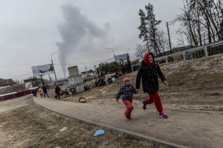 Una madre intenta escapar del fuego ruso con su hijo.