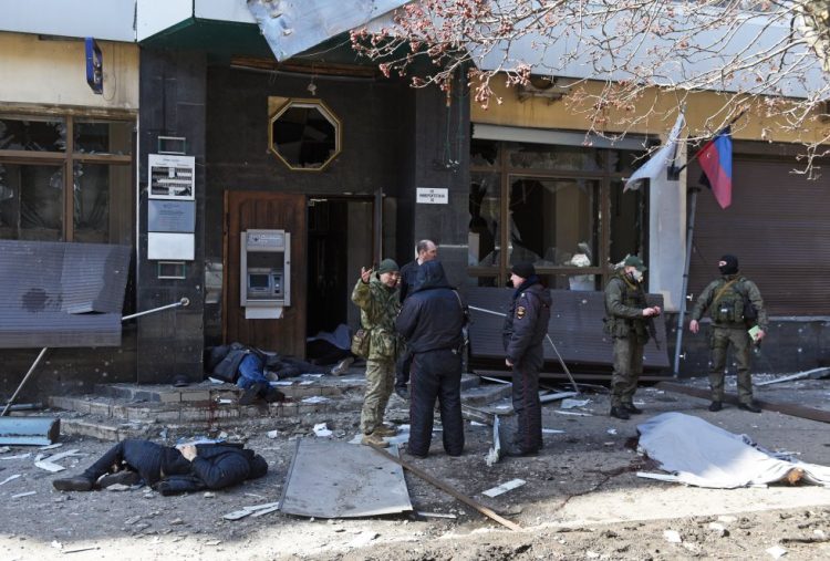 Policías junto a los cuerpos de civiles tras el ataque ucraniano en Donetsk.