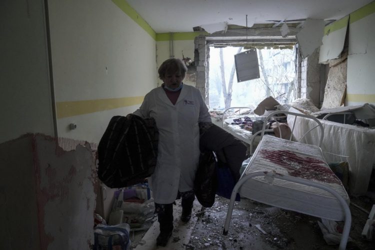 Una enfermera recupera colchas que se salvaron del hospital destruido en la ciudad de Mariupol.