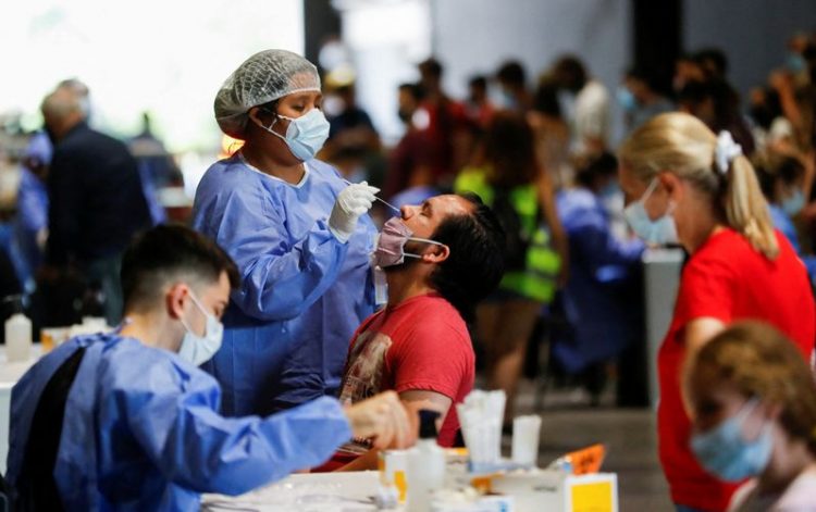 A healthcare worker takes a swab sample from a man to be tested for the coronavirus disease (COVID-19), at La Rural, in Buenos Aires, Argentina December 23, 2021. Picture taken December 23, 2021. REUTERS/Agustin Marcarian