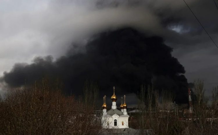 Una iglesia ortodoxa delante de una refinería de petróleo que se incendió tras un ataque ruso cerca de Odesa.