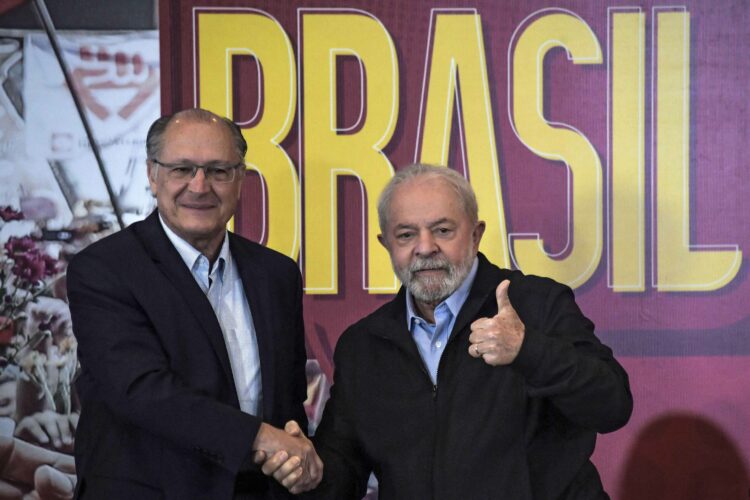 Former President (2003-2010) Luiz Inacio Lula da Silva (R) gives the thumb up as he shakes hands with former Sao Paulo's Governor (2001-2006 and 2011-2018) Geraldo Alckmin (L), during the launch of their government program guidelines, with representatives of political parties that support their presidential campaign for the October elections, in Sao Paulo, Brazil, on June 21, 2022. (Photo by NELSON ALMEIDA / AFP)