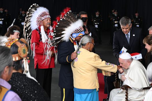 Francisco besa la mano de una mujer indígena durante su bienvenida.