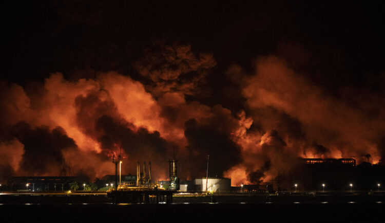 Flames and smoke rise from a massive fire at a fuel depot sparked by a lightning strike in Matanzas, Cuba, early on August 8, 2022. - Aircraft, firefighters and specialists from Mexico and Venezuela arrived in Cuba on August 7 to help put out a massive fire at a fuel depot that has left at least one person dead, 121 people injured and 17 firefighters missing. (Photo by YAMIL LAGE / AFP)
