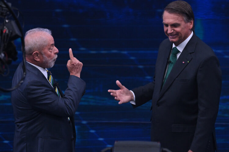 Brazilian former president (2003-2010) and presidential candidate for the leftist Workers Party (PT), Luiz Inacio Lula da Silva (L), and Brazilian President and presidential candidate Jair Bolsonaro (R) gesture during a televised presidential debate in Sao Paulo, Brazil, on October 16, 2022. - President Jair Bolsonaro and former President Luiz Inácio Lula da Silva face each other this Sunday night in the first face-to-face debate, in which they will try to take advantage 14 days before the second round of the presidential elections in Brazil. (Photo by NELSON ALMEIDA / AFP)