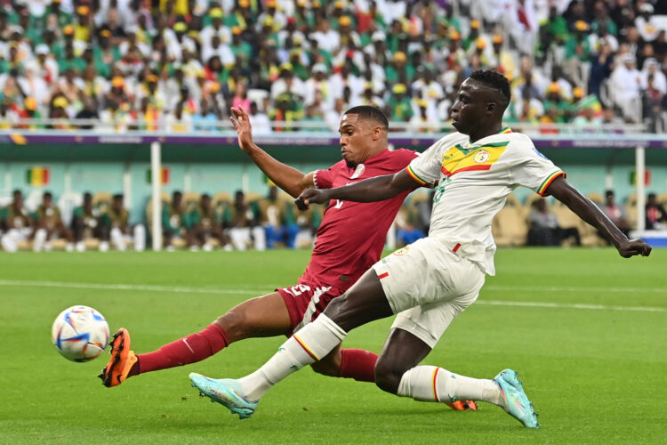 Qatar's defender #02 Pedro Miguel (L) fights for the ball with Senegal's forward #15 Krepin Diatta (R) during the Qatar 2022 World Cup Group A football match between Qatar and Senegal at the Al-Thumama Stadium in Doha on November 25, 2022. (Photo by Glyn KIRK / AFP)