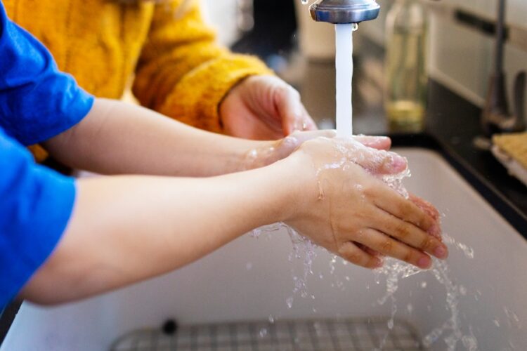 Boy washing his hands to lessen the chance of COVID-19