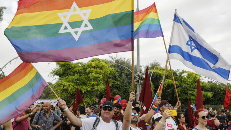 Participants wave gay rainbow pride flags during the 18th annual Jerusalem Gay Pride parade on June 06, 2019. - Thousands were expected to participate in Jerusalem's annual Gay Pride march Thursday under high security following a knife attack by a Jewish religious extremist that killed a teenager in 2015. Police were deploying some 2,500 undercover and uniformed officers for the parade that starts at a park in the Holy City and continues through nearby streets in the late afternoon and into the evening. (Photo by MENAHEM KAHANA / AFP)