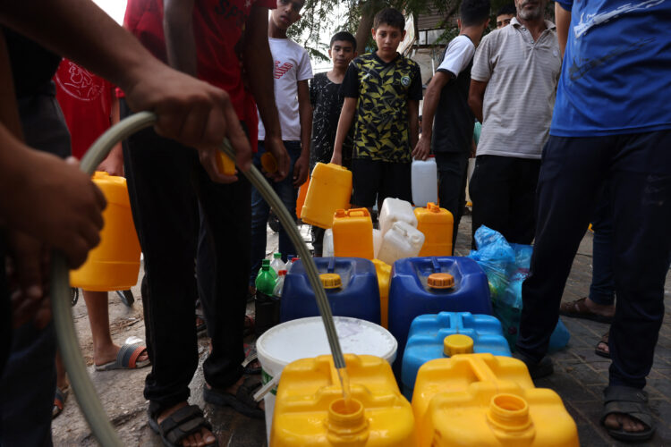 Palestinians queue to refill on water in Rafah refugee camp in the southern of Gaza Strip, on October 14, 2023. Thousands of Palestinians fled on October 14 to southern Gaza seeking refuge after Israel warned them to evacuate before an expected ground offensive against Hamas in retaliation for the deadliest attack in Israel's history. (Photo by MOHAMMED ABED / AFP)