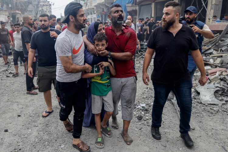 Una familia palestina consuela a un niño mientras abandonan su casa en Gaza.