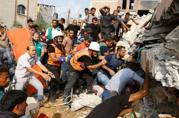 Voluntarios buscaban supervivientes entre los escombros de un edificio bombardeado por Israel en la franja de Gaza.