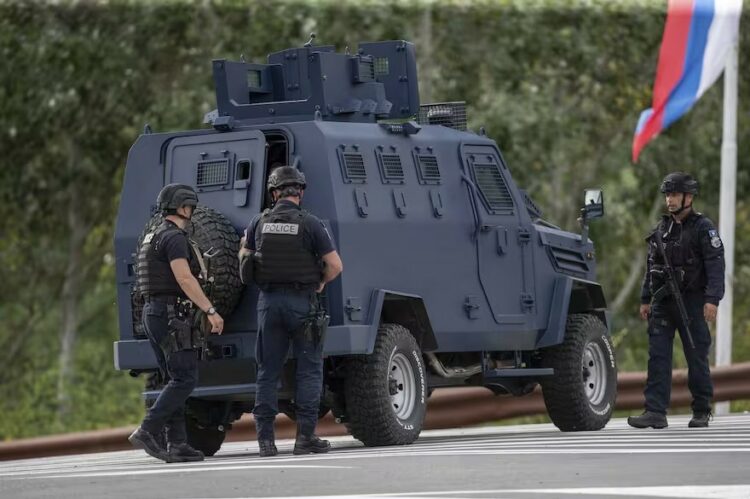 Agentes de policía de Kosovo vistos cerca de un vehículo blindado aseguran un cruce de caminos que conduce al Monasterio de Banjska.