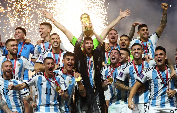 Soccer Football - FIFA World Cup Qatar 2022 - Final - Argentina v France - Lusail Stadium, Lusail, Qatar - December 18, 2022 Argentina's Lionel Messi lifts the World Cup trophy alongside teammates as they celebrate after winning the World Cup REUTERS/Kai Pfaffenbach