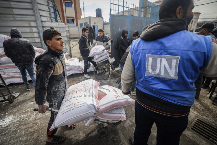 Displaced Palestinians receive food aid at the United Nations Relief and Works Agency for Palestine Refugees (UNRWA) center in Rafah in the southern Gaza Strip on January 28, 2024, amid ongoing battles between Israel and the Palestinian militant group Hamas. Israel has alleged several UNRWA staff were involved in Hamas's October 7 attack, leading some key donor countries to suspend funding and the agency to fire several staff over the claims, in a row between Israel and UNRWA a day after the UN's International Court of Justice ruling on January 26 that Israel must prevent possible acts of genocide in the conflict and allow more aid into Gaza. (Photo by AFP)