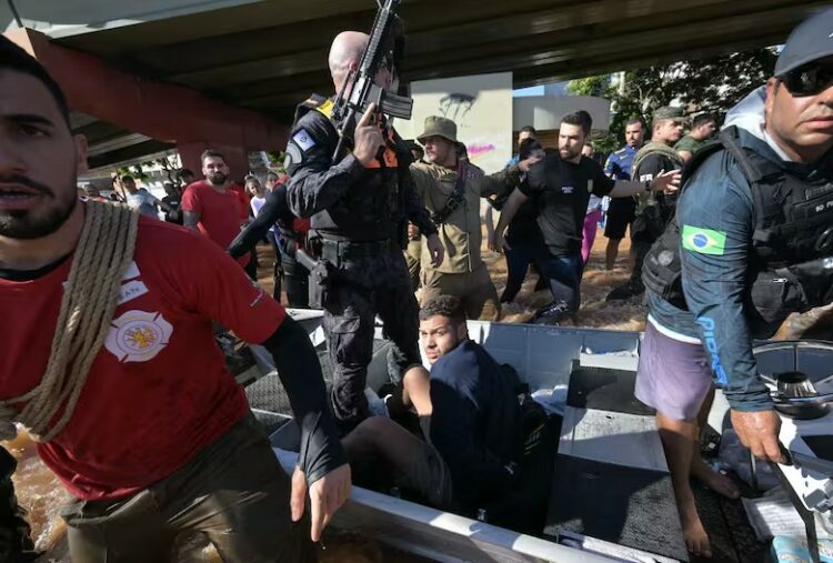 Las fuerzas de seguridad custodian a un hombre arrestado por presuntamente robar casas tras las inundaciones provocadas por las fuertes lluvias en Porto Alegre, estado de Rio Grande do Sul, Brasil.