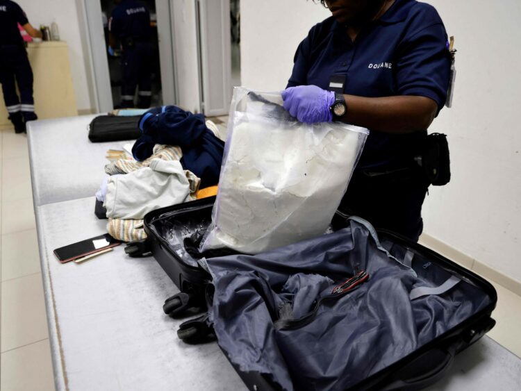 Funcionarios de la Aduana francesa descubren bolsas con cocaína escondidas en una valija que iba rumbo a París, en el aeropuerto de Cayenne, en la Guyana Francesa. Foto: AFP.