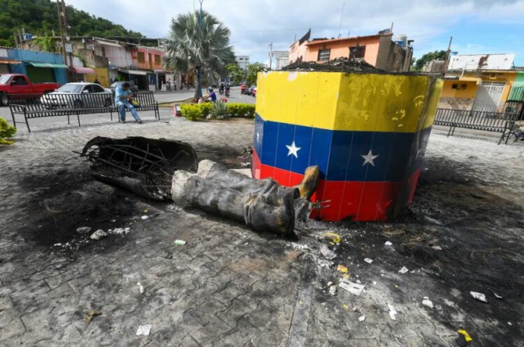 Una estatua destruida de Hugo Chávez tras las protestas masivas yace junto a su base en la ciudad de Valencia.