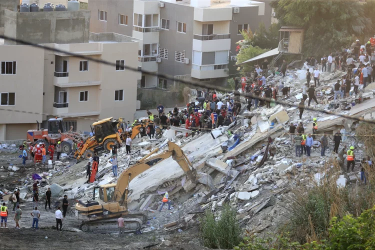 Personas y equipos de rescate buscan víctimas luego de que un ataque aéreo impactara en dos edificios adyacentes en el barrio de Ain el-Delb, el este de la ciudad portuaria de Sidón, en el sur del Líbano.