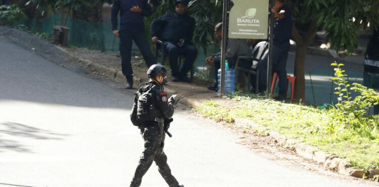 Miembro del Servicio Bolivariano de Inteligencia Nacional (SEBIN) vigila la calle junto a la residencia del embajador argentino, donde los miembros de la oposición venezolana han buscado asilo desde marzo.