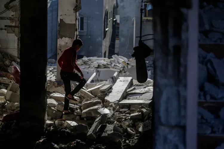 Palestinos ayer, rodeados de escombros tras nuevos bombardeos israelíes.