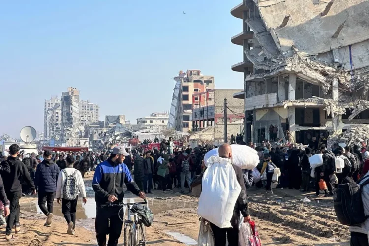 Palestinos desplazados internos caminan por la carretera Al Rashid, en el centro de Gaza, hacia el norte de la Franja.