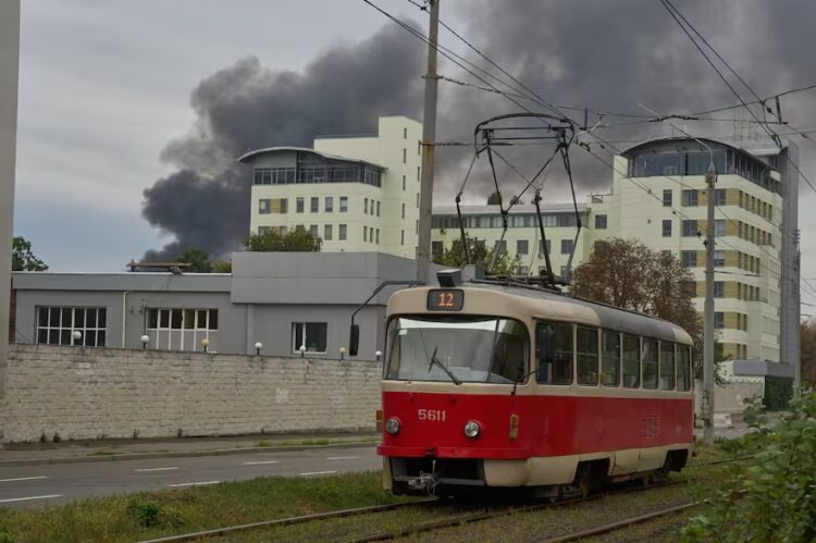 Un tranvía circula con el humo de fondo durante el masivo ataque con drones y misiles de Rusia en Kiev.