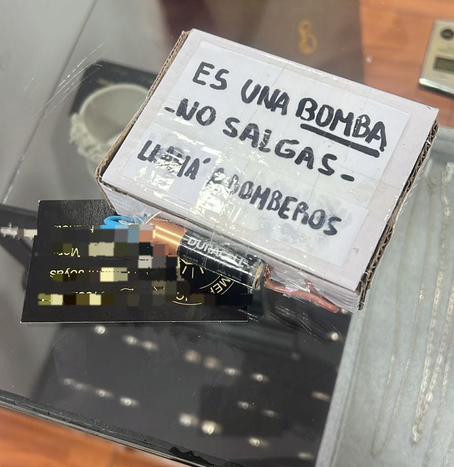 Caja de aproximadamente 10 por 10 centímetros con la leyenda "Es una bomba, no salgas, llamá a bomberos".