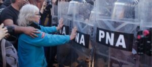 2025 cerró con 3.893 piquetes, la cifra más baja desde 2011. Mujer frente a fuerzas de seguridad.