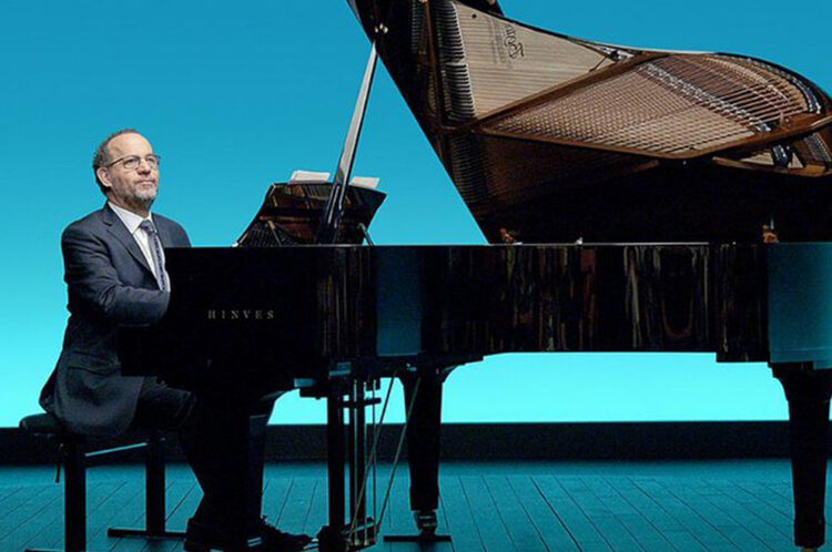 El pianista y director Sergio Feferovich toca el piano mientras explica e interactúa con el público, combinando humor, música y participación para una experiencia única.