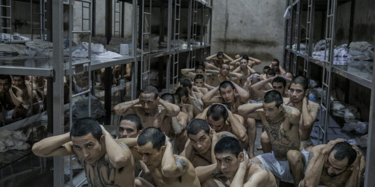 Gang members inside their cell as they prepare to be removed in order to do a thorough search by prison guards at the  CECOT - Terrorism Confinement Center.