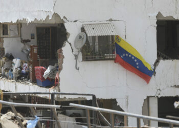 Una bandera nacional venezolana vista en un edificio residencial dañado luego de que se registraran dos terremotos, en Playa Grande, estado La Guaira, Venezuela.