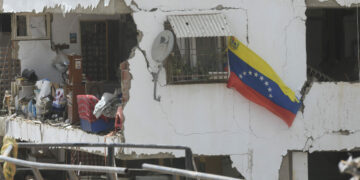 Una bandera nacional venezolana vista en un edificio residencial dañado luego de que se registraran dos terremotos, en Playa Grande, estado La Guaira, Venezuela.