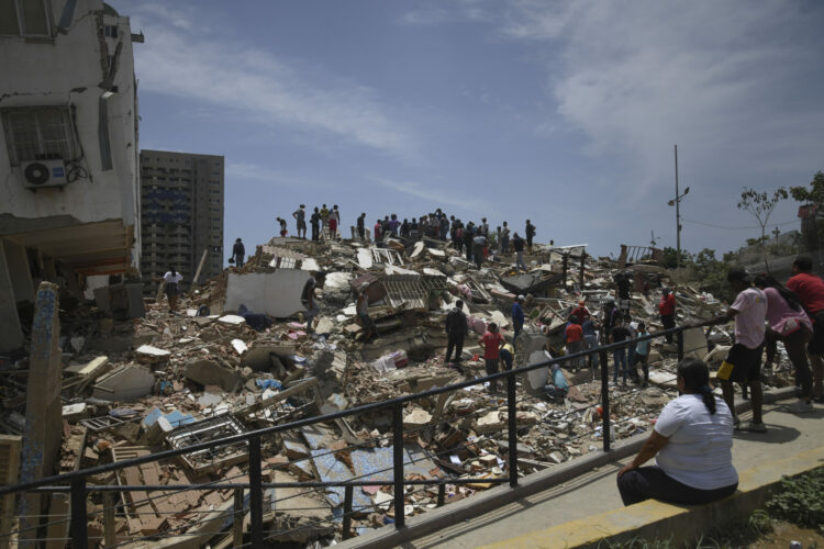 Personas son vistas sobre los escombros de un edificio derrumbado luego de que se registraran dos terremotos, en Playa Grande, estado La Guaira, Venezuela.