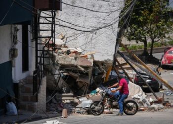 Un hombre observa los escombros de un edificio colapsado en Pereira, Colombia.