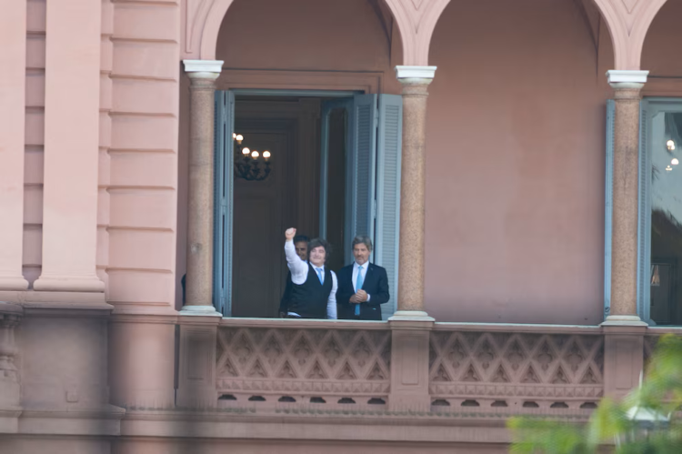 El presidente Milei saluda desde el balcón de la Casa Rosada.
