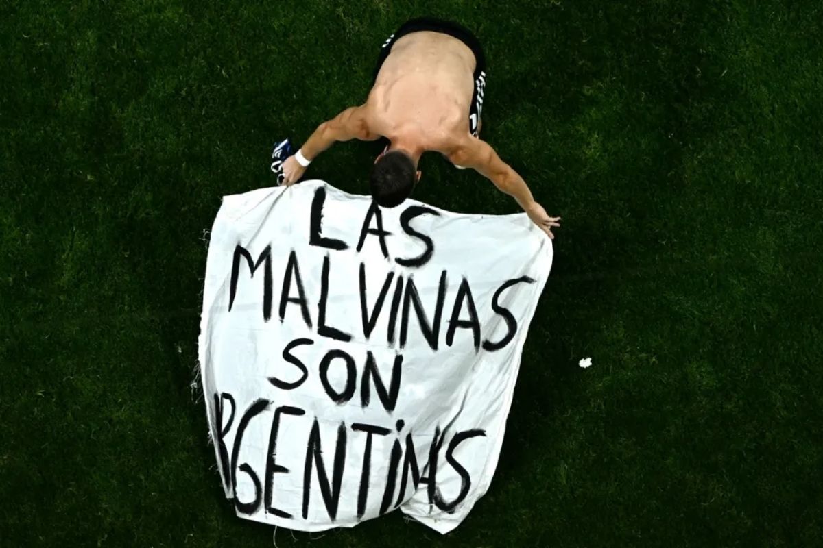 El futbolista argentino Giovani Lo Celso coloca una bandera con un reclamo histórico del país: "Las Malvinas son argentinas", después de la semifinal contra Inglaterra, en Atlanta. Foto: Jewel Samad / AFP via Getty Images.